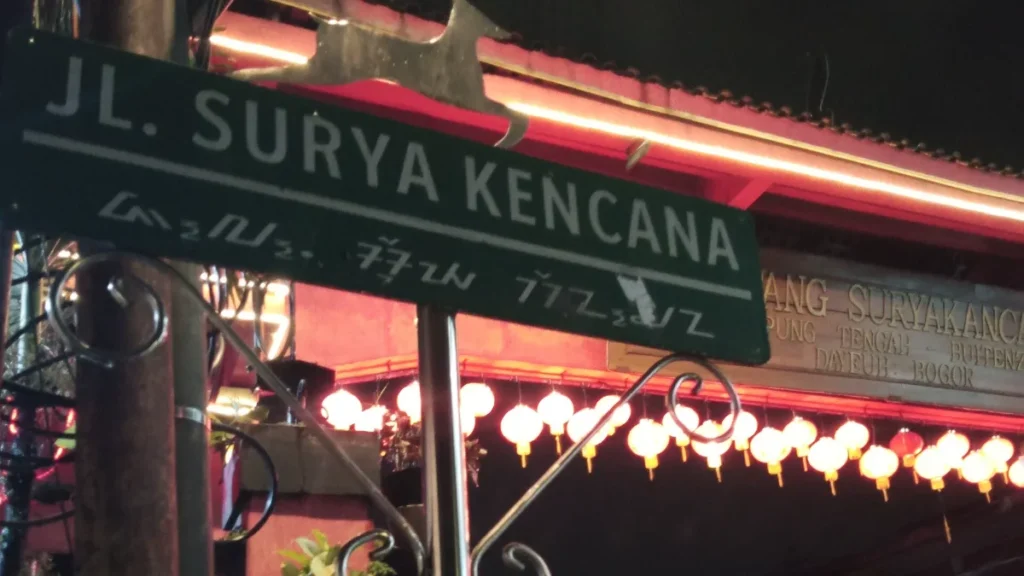 Papan nama Jalan Surya Kencana dengan deretan lampion di kawasan Pecinan Bogor pada malam hari