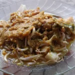 Sepiring toge goreng berisi tauge dan mi dengan siraman bumbu oncom