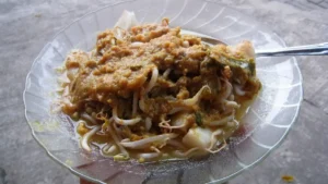 Sepiring toge goreng berisi tauge dan mi dengan siraman bumbu oncom