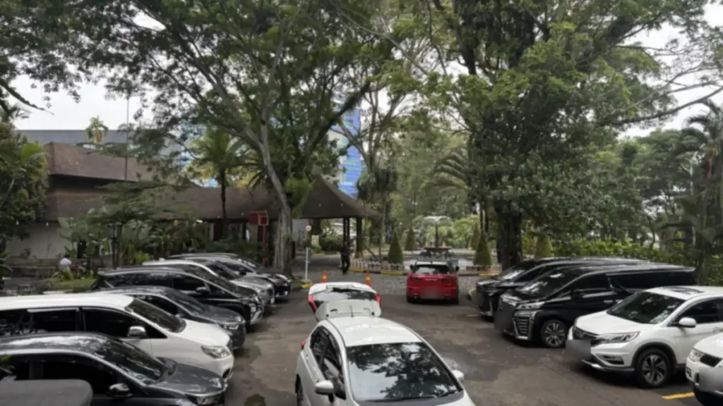 Area parkir kawasan Taman Budaya Sentul City yang dinaungi pepohonan besar, dekat deretan kafe dan restoran